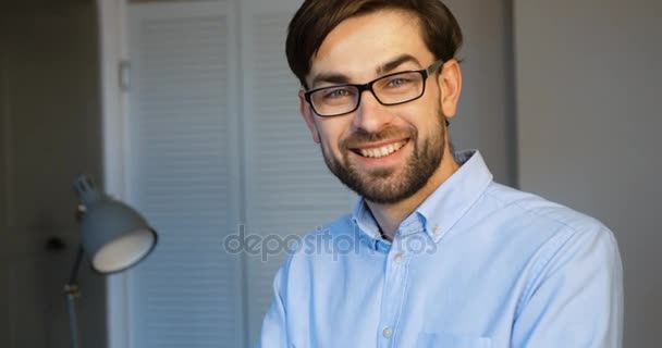 Lächelnder Geschäftsmann, der im Büro vor der Kamera posiert. Nahaufnahme. — Stockvideo