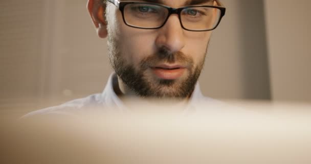 Homem de negócios jovem atraente que trabalha no computador portátil no escritório. Homem de negócios de óculos. Inteligente. Fechar . — Vídeo de Stock