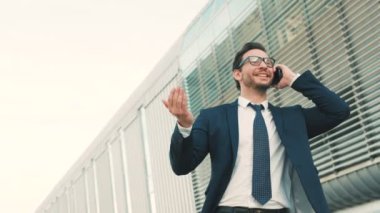 Ofis dışında cep telefonu konuşurken, iyi haber işitme ve yetiştirme çekici beyaz işadamı eller. Çok mutlu bir adam. Yakın çekim