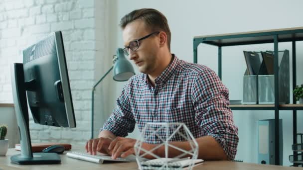 Atractivo hombre de negocios serio que trabaja en la computadora, tomando lápiz y tomar algunas notas en el cuaderno de notas en la oficina . — Vídeos de Stock