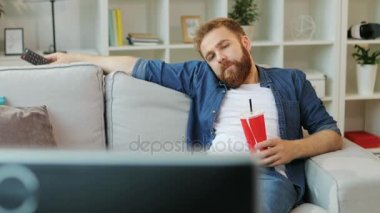 Sıkıcı ve çalışırken duygu tişörtlü çekici adam bulmak ilginç bir şey oturma odasında otururken.