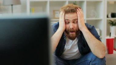 Evde oturma odasında kanepede otururken süre duygusal adam izlerken futbol maç patlamış mısır ve coca cola ile.