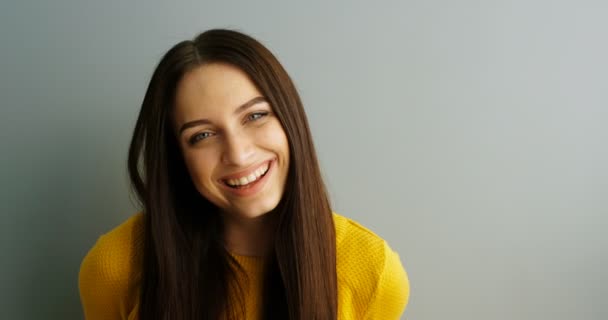 Mulher bonita sorrindo e rindo para a câmera. Retrato de jovem atraente olhando para a câmera. Retrato de mulher. No interior. Um tiro de perto. Retrato tirado — Vídeo de Stock