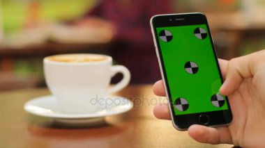 Siyah smartphone ile yeşil ekran açık havada kafede otururken holding erkek eller yukarı kapatın. Kaydırma adam. dokunmatik ekran yakınlaştırma. Hareket izleme. Chroma anahtar