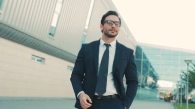 Bina ve gözlükleri çıkar atıyor ve doğruca kameraya bakarak office center yakınındaki yürüme çekici şık bir iş adamı. yakın çekim. Portre