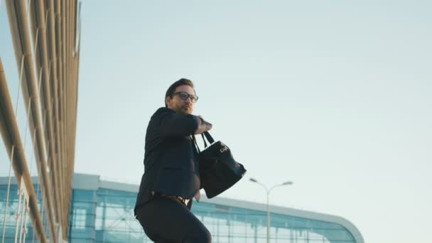 Empresario haciendo locuras, movimientos divertidos mientras está parado al aire libre cerca del edificio de oficinas. Hombre de negocios bailando, haciendo movimientos de manos ninjas. de cerca — Vídeos de Stock