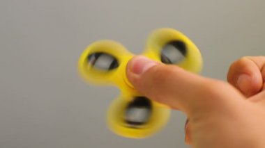 Sarı spinner kıpır aygıtı elinde. Adam yeni iplik oyuncakla oynamak. Orta yatakları ile popüler Gadget'ı