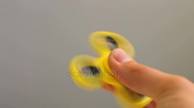 Sarı spinner kıpır aygıtı elinde. Adam yeni iplik oyuncakla oynamak. Orta yatakları ile popüler Gadget'ı
