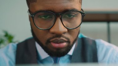 Ofiste dizüstü bilgisayar kullanan Afrikalı-Amerikalı iş adamı. Tipik dizüstü klavye ve ekran monitör seyir siyah ofis çalışanı. Yakın çekim