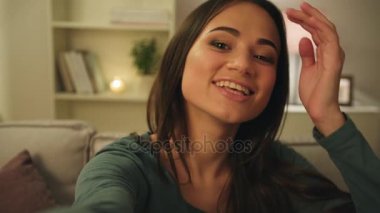 Akşam kanepede oturan ve arkadaşlarınızla görüntülü görüşme sahip çekici genç kadın. Video sohbet. Yakın çekim