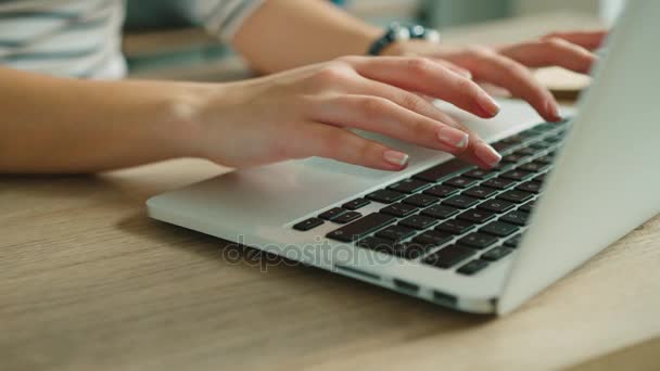 Женщина печатает на клавиатуре ноутбука в офисе. Закройте руки женщины, пишущей на клавиатуре ноутбука . — стоковое видео