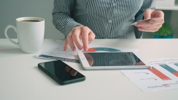 Vrouw aankopen vanaf het internet met haar creditcard op tablet pc in het kantoor. Close-up. Van bovenaf bekijken — Stockvideo