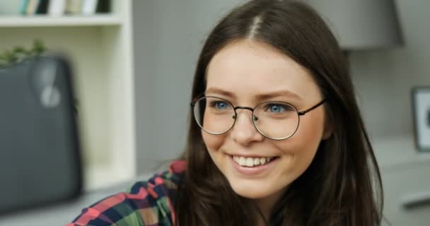 Hermosa chica adolescente tomando selfies mientras se sienta en el sofá en casa. Chica sonriendo a la cámara y haciendo fotos. De cerca. — Vídeos de Stock