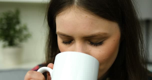 Tiener meisje drinken koffie, thee en kijken naar de camera. Portret geschoten. Close-up — Stockvideo