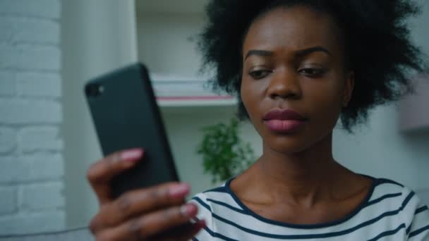 Mujer afroamericana negra usando un teléfono inteligente en la oficina, en casa. Navegar por Internet, leer noticias. De cerca. — Vídeo de stock