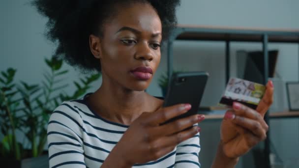 Mujer afroamericana negra de compras en línea con tarjeta de crédito y teléfono inteligente en la oficina. Mujer con tarjeta de crédito y pedidos de bienes — Vídeo de stock