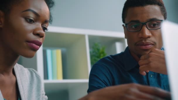 Equipo de dos empresarios afroamericanos trabajando juntos en la oficina. Hombre de negocios y mujer de negocios afroamericanos hablando, usando computadora portátil, revisando las cartas financieras. De cerca. — Vídeos de Stock