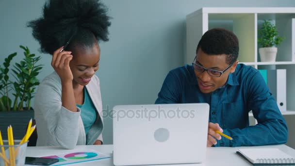 Афро-американських бізнес команди працюють разом в офісі з фінансових діаграми та портативний комп'ютер. — стокове відео