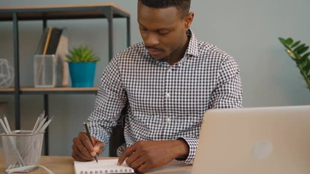 Homem de negócios afro-americano a trabalhar no escritório. Homem negro escrevendo no notebook do computador portátil — Vídeo de Stock