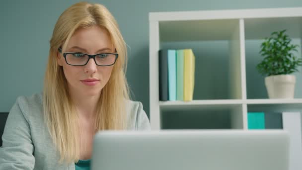 Привлекательная блондинка-бизнесвумен, работающая с ноутбуком в офисе — стоковое видео