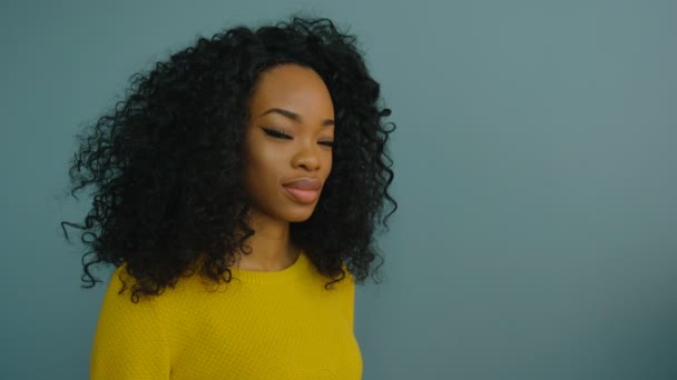 Retrato de bela mulher negra afro-americana olhando para a câmera e sorrindo. Fundo cinzento — Vídeo de Stock