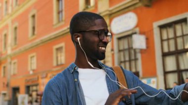 Şık genç Afro-Amerikan turist gözlük ve kulaklık ile arkadaş şehir merkezinde cep telefonu kullanarak video sohbet.