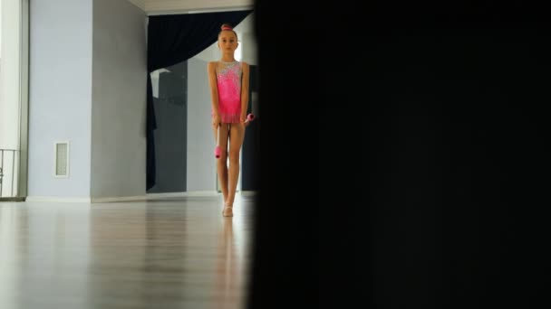 Menina de cabelo loira jovem fazendo exercício com maça na mão no estúdio no fundo da janela de luz. Vista de baixo . — Vídeo de Stock