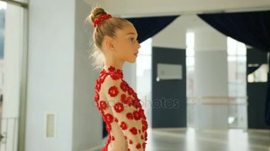 Küçük zarif jimnastik kırmızı kurdele beyaz Studio kamera önünde iplik yan portresi.
