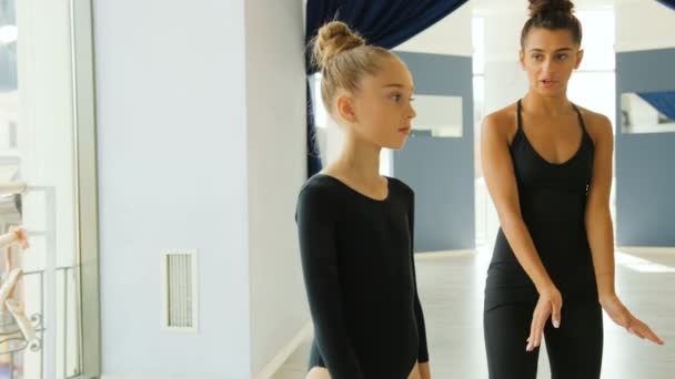 Portrét roztomilý dívka a její mladý učitel dělá nácvik některé prvky v baletní studio na pozadí města.
