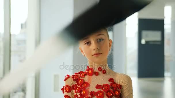 Close up portrait of cute girl spinning the colorful ribbon in front of camera in the stylish studio. — Stock Video