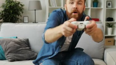 Koç ve evde Xbox'ta oyun oynamaya başlamak için atlama mutlu duygusal adam.