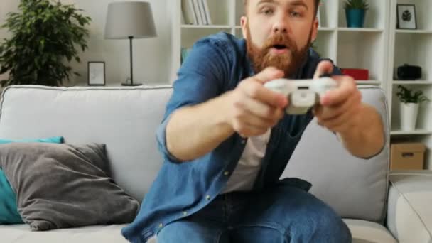 Gelukkig emotionele man springen naar de trainer en beginnen te spelen spel op xbox thuis. — Stockvideo