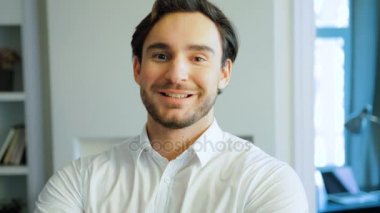 Genç adam beyaz gömlek gülümseyen portresi. Kameraya bakarak sakallı mutlu beyaz adam. Kapalı.