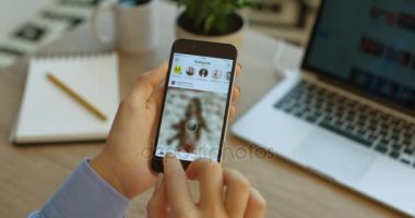 New York - 17 Ocak 2016: sosyal medya. Instagram app akıllı telefon kullanan kadın. El resimleri, fotoğrafları instagram uygulama içinde kaydırma.