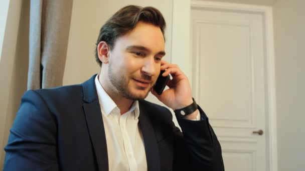 Πλευρική όψη του το πορτρέτο του Καυκάσου νέοι επαγγελματίες άνθρωπος στο κοστούμι και πουκάμισο μιλάμε με επιχειρηματικό εταίρο για το κινητό τηλέφωνο στο γραφείο. — Αρχείο Βίντεο