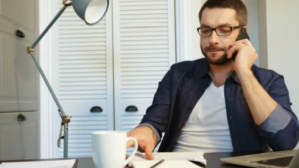 Młody biznes kaukaski mężczyzna w okularach rozmieszczenie w stylowe nowoczesne biuro i rozmowy na telefon komórkowy z partnerem biznesowym. Wewnątrz.. — Wideo stockowe