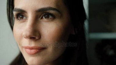 Rüya ve içme kahve kupa penceresine bakarak güzel genç kadın portresi kadar çok yakın.