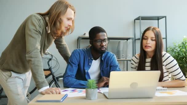 Multi-etniska business-team, kaukasiska business man och kvinna, afrikansk man arbetar i moderna kontors och med laptop. — Stockvideo