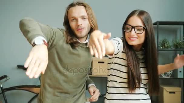 Donna d'affari emotiva negli occhiali e uomo con i capelli lunghi divertirsi in ufficio moderno durante la pausa pranzo  . — Video Stock