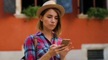 Akıllı telefondaki şehrin sokak online harita kullanarak şapkalı yakışıklı kadın portresi. Yan görünüm.