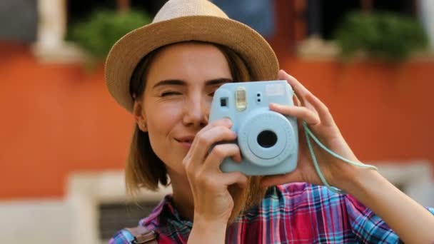 Nära upp skott av vackraste kvinnan att ta bilder på den eleganta blå kameran på orange vägg bakgrunden. — Stockvideo