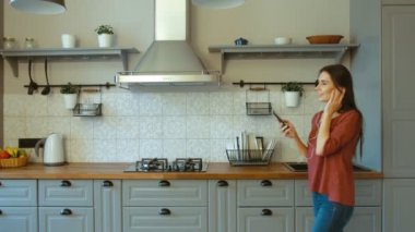 Müzik dinlerken modern mutfağında dans mutlu bir kadın. Yakın çekim