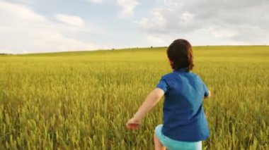 Düşünce sarı alan çalışan ve ahşap uçak ile oynayan genç mutlu çocuk. Arkadan görüntülemek.