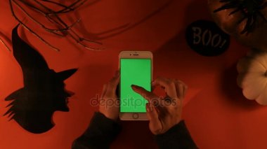 Halloween pumpkins, kağıt cadı ve smartphone ile turuncu masada Yeşil perde konseptiyle. Chroma anahtar. Düz yatıyordu. Üstten Görünüm