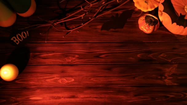 На старом деревянном столе лежала Хэллоуинская квартира с тыквами, свечами и летучими мышами. Вид сверху. Страшные руки — стоковое видео