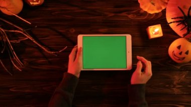 Kadın kaydırma, yakınlaştırma sayfaları beyaz tablet. Eski ahşap masa üzerinde Halloween üstten görünüm kabaklar ve mum. Chroma anahtar.