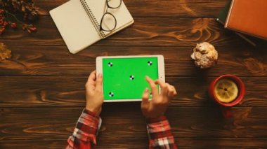 Sonbahar konsepti üstten görünüm. Ahşap masa üzerinde yatay konumda yeşil ekranlı tablet aygıtı kullanan kadın. Düz yatıyordu. Chroma anahtar. Hareket izleme