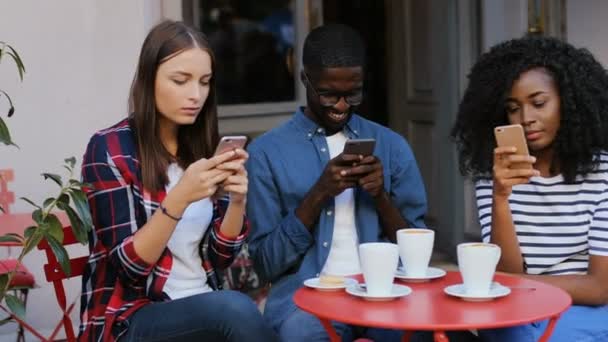 Freunde benutzen Mobiltelefone im Café — Stockvideo