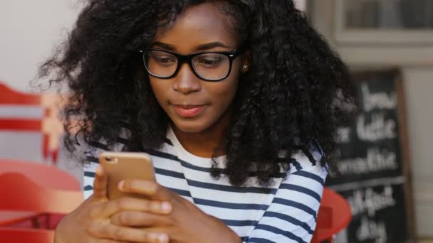 Afrikansk kvinna i glasögon använder mobila — Stockvideo