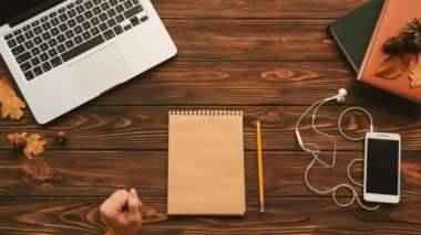 Kadın not defterinde ahşap masanın üzerine yazma. 2018 için planlar. Laptop omputer, ahşap masa kitap. Üstten Görünüm